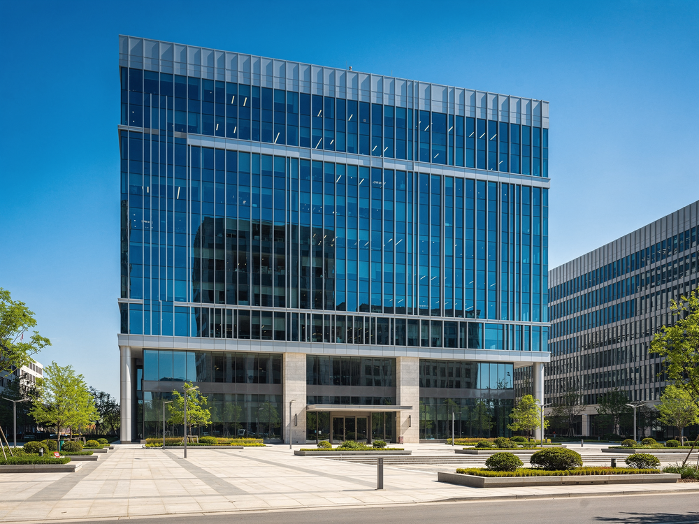A modern multi-story commercial office building with a glass and steel facade on a clear day