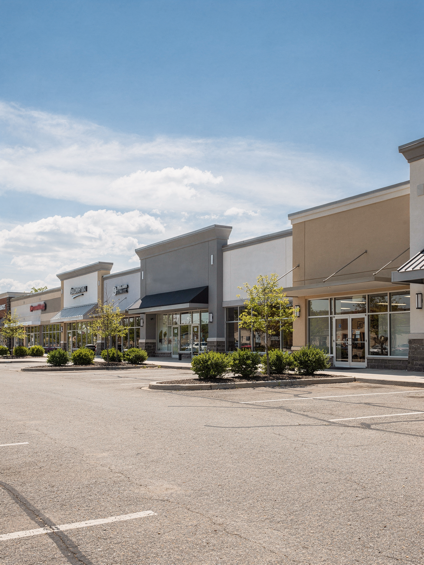 A bright, well-kept multi-tenant commercial retail plaza on a clear day